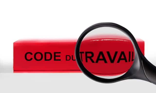 Code du travail français avec un loupe agrandissant le mot travail